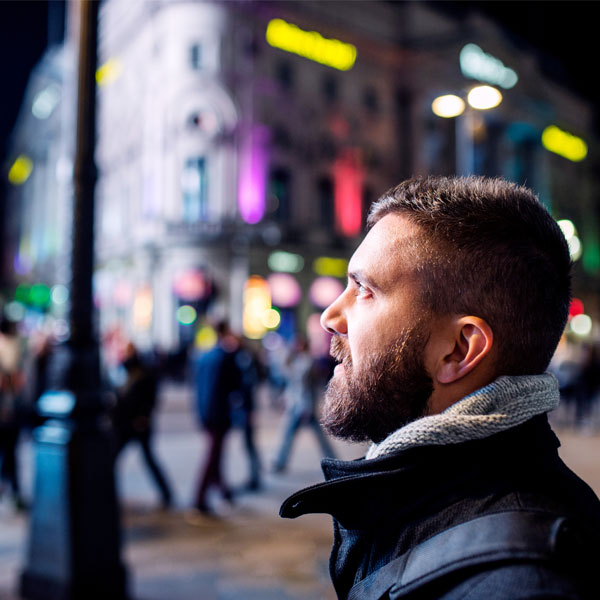 Man looking to the side in night time city