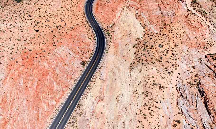 A long, straight highway cuts through a desert
