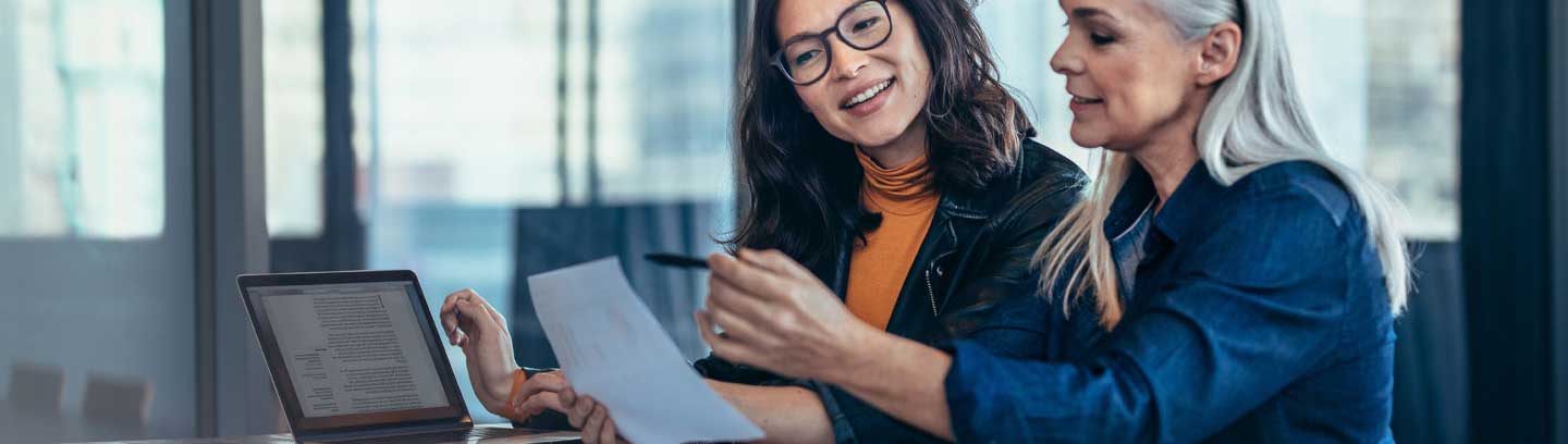 Image depicting two business women reviewing a document