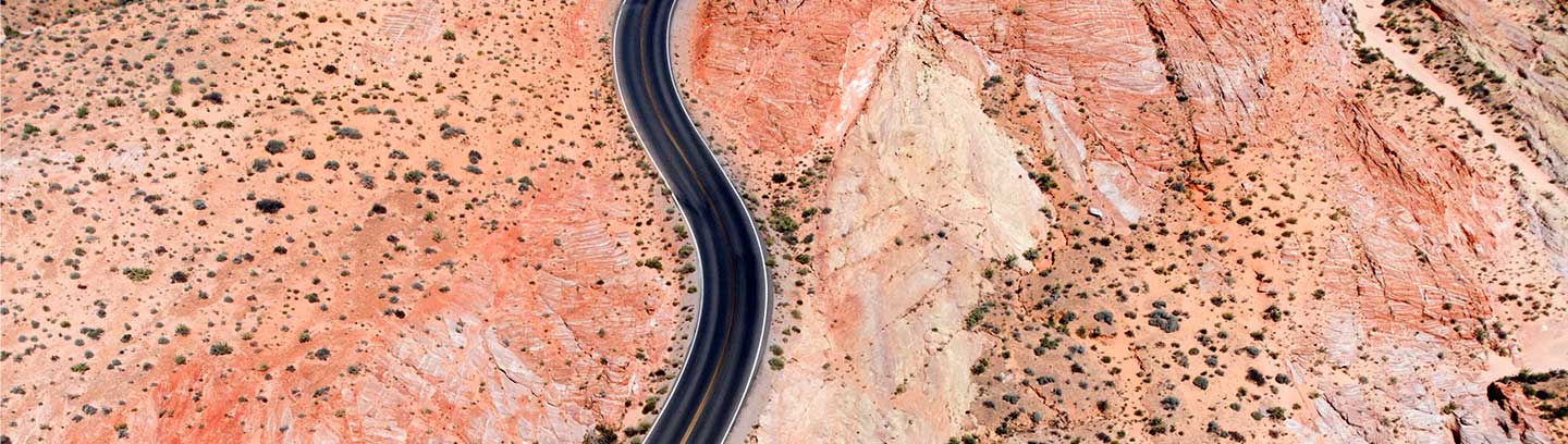 A long, straight highway cuts through a desert