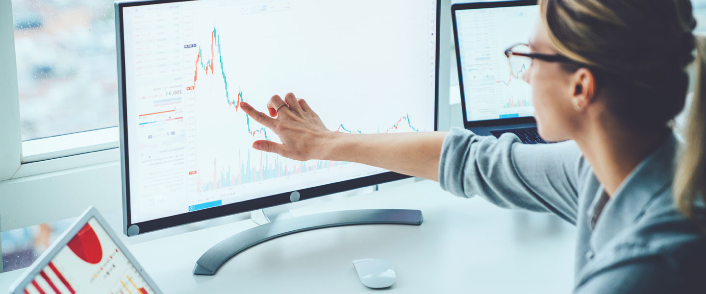 A business woman pointing at a graph on her computer screen