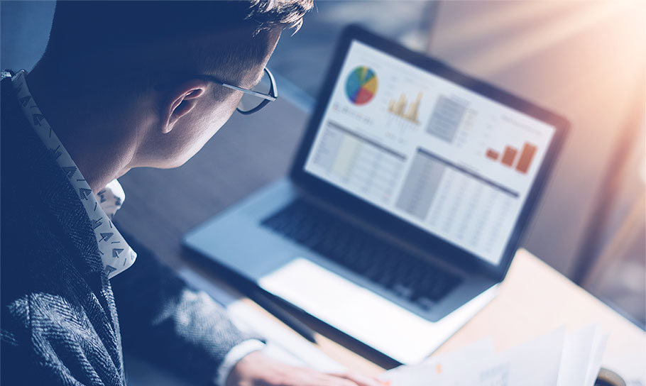 Man working on financial and market analysis using a laptop